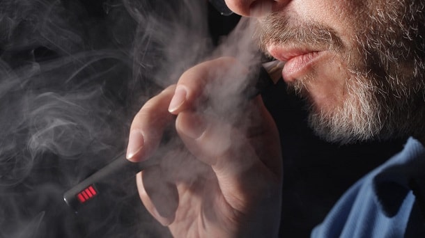 держит в руке в форме карандаша